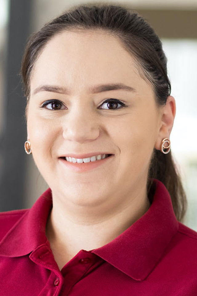Portrait von Mergime Cekaj. Sie hat langes dunkles Haar und trägt ein burgunda farbenes Poloshirt