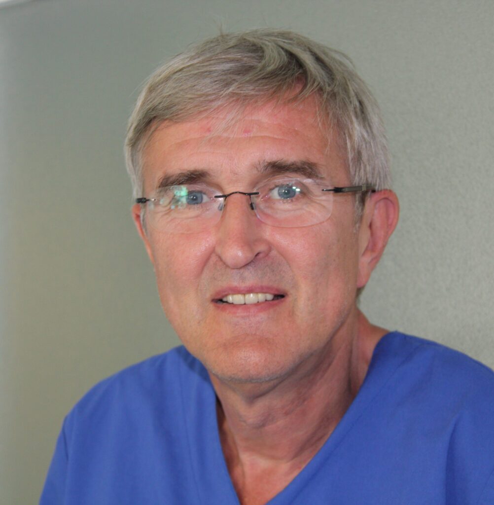Dr. med. dent. Helmut Steveling: Portrait eines älteren Mannes mit Brille in einem blauen Kasack